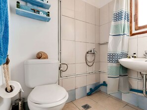 Ein Badezimmer mit Toilette, Dusche und Waschbecken.