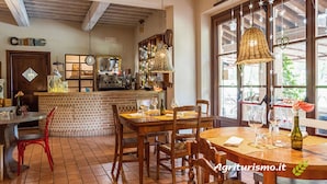 A cozy restaurant with wooden furniture, a brick counter, and large windows. - Cottage in Umbria With Pool & Garden (Citta della Pieve)