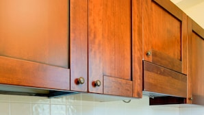 Una cocina con armarios de madera y salpicadero de azulejos blancos.