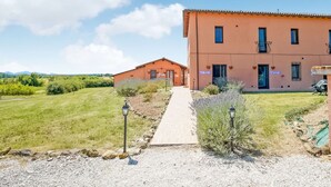 A two-story building with a gravel driveway leading to a wooden pathway. - Holiday Home Near Castiglione del Lago (Castiglione del Lago)