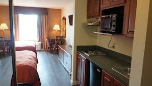 A hotel room with two beds, a kitchenette, a dining area, and a bathroom. - Scotland Neck Inn (Scotland Neck)