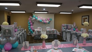 A room with tables set up for an event, decorated with balloons and floral arrangements. - Scotland Neck Inn (Scotland Neck)