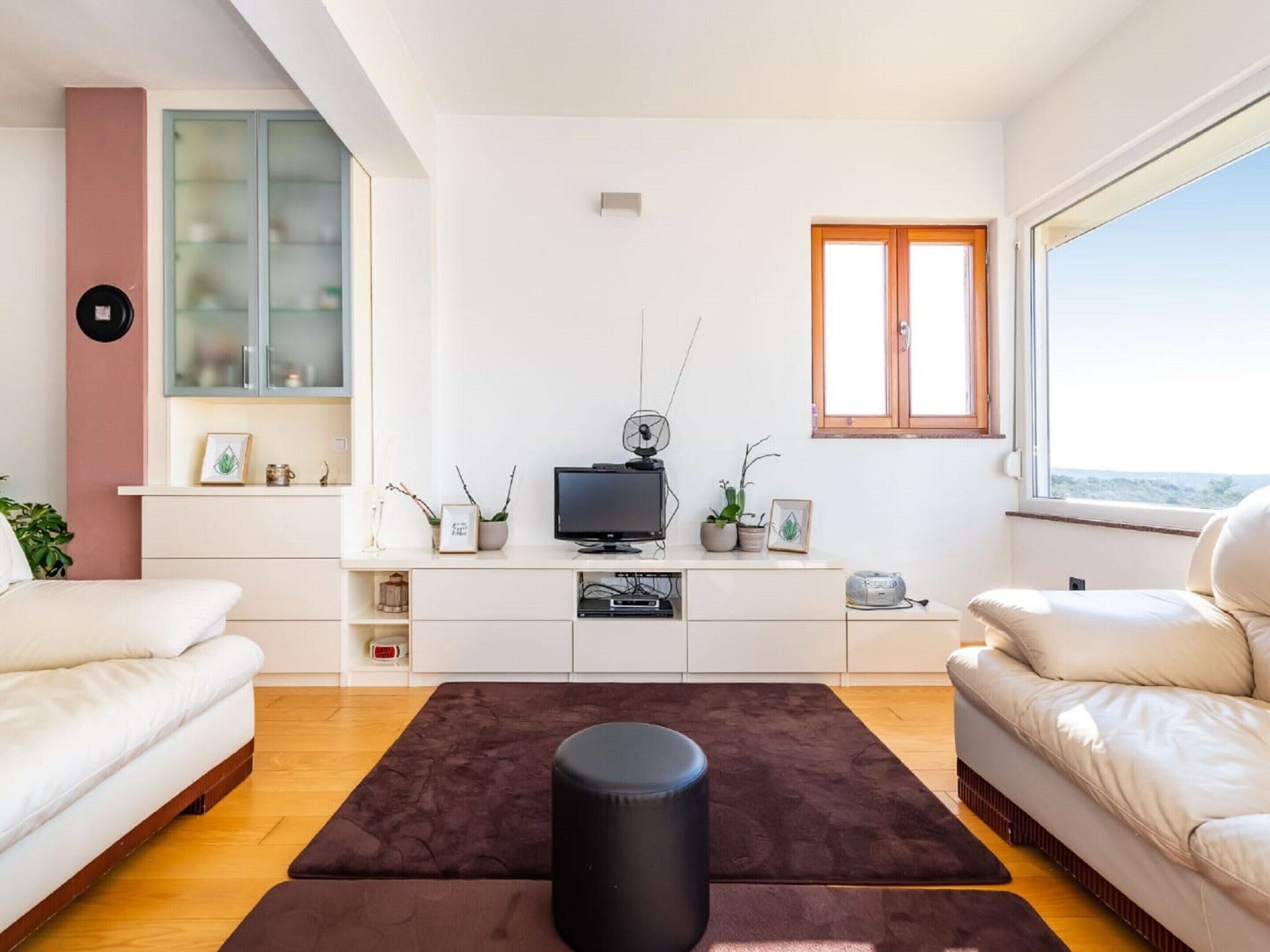 Una sala de estar moderna con un televisor de pantalla plana, una mesa de centro y dos sofás.