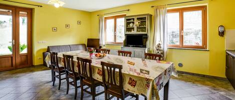 A dining area with a table set for six, surrounded by wooden chairs.