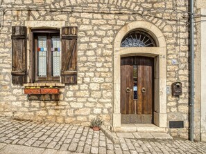 A stone building with a wooden door and window, a mailbox, and a potted plant. - Elegant Apartment in Buonalbergo near Town Center (Buonalbergo)