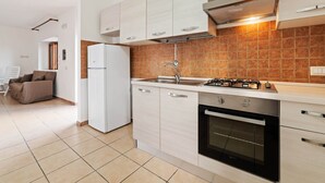 A modern kitchen with white cabinets, a built-in oven, and a gas stove. - Apartment in Agropoli With Garden (Agropoli)