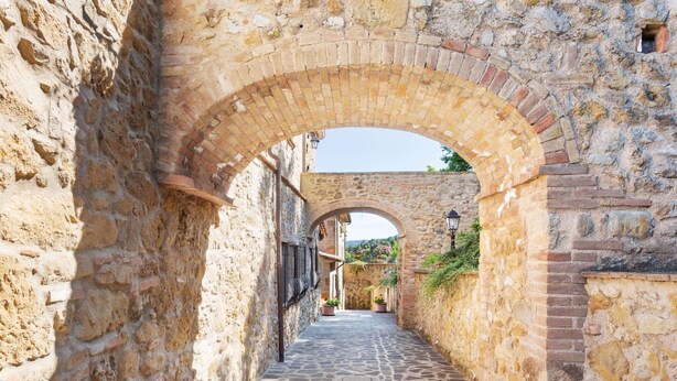 A narrow stone pathway flanked by old stone walls and arches, leading to a building with a visible entrance. - Holiday Home in Volterra With Pool & Views (Volterra)