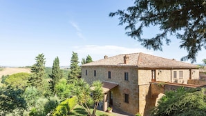 A stone building with a tiled roof, surrounded by lush greenery and trees. - Holiday Home in Volterra With Pool & Views (Volterra)