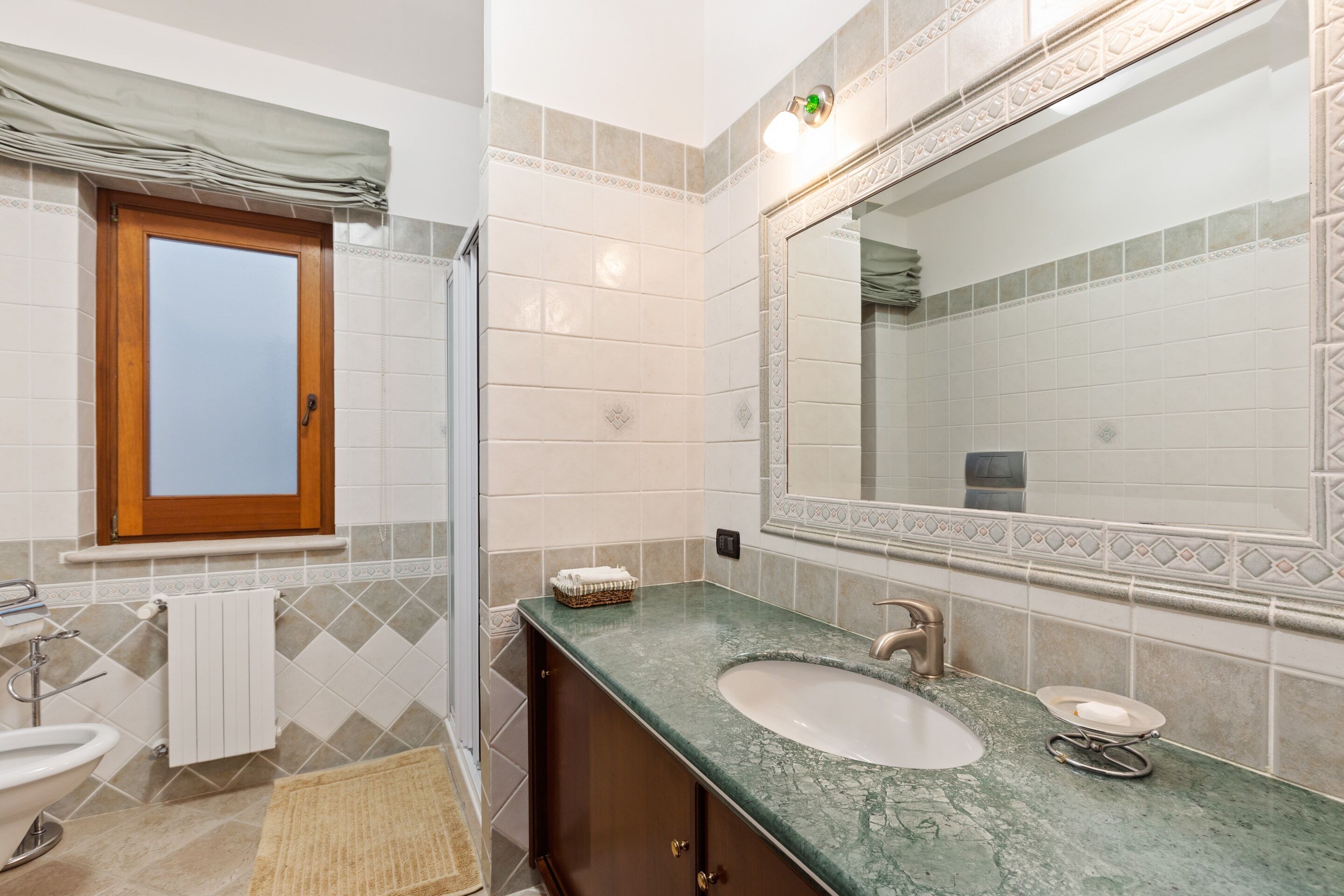 A bathroom with a sink, mirror, and towel rack.