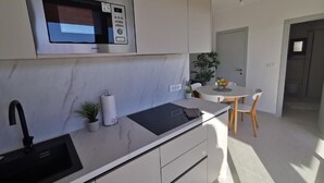 A modern kitchen with a built-in microwave, a sink, and a small countertop area. - Enticing Mobile Home in Pakoštane With Swimming Pool (Pakostane)
