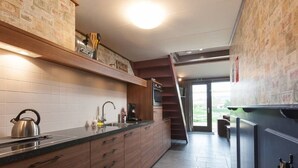 Eine moderne Küche mit Holzausstattung, einem Edelstahlkocher und einer Kaffeemaschine.