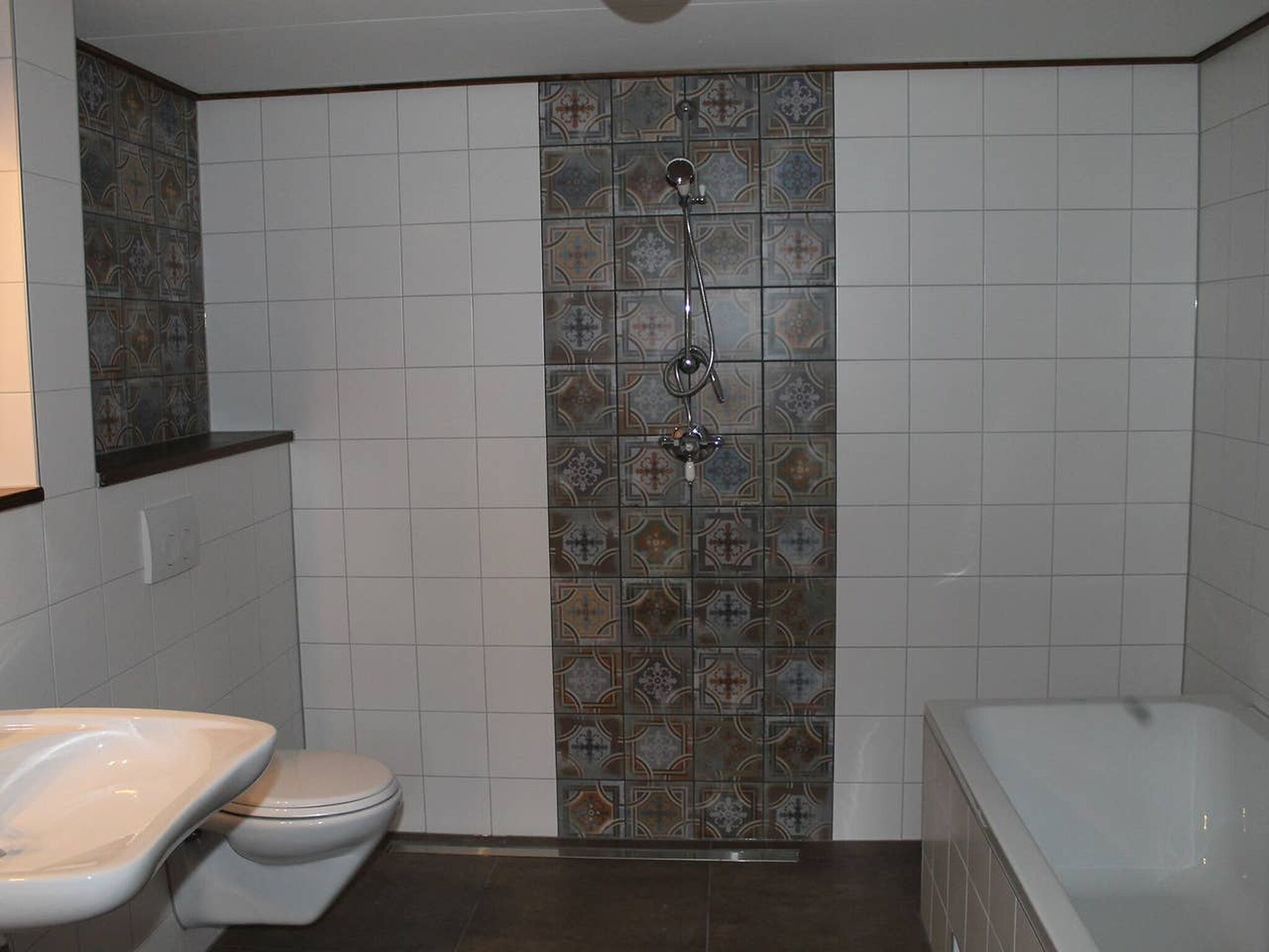A bathroom with a shower, toilet, and bathtub.