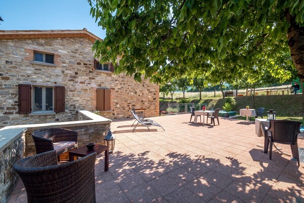 A stone building with outdoor seating and a patio area.
