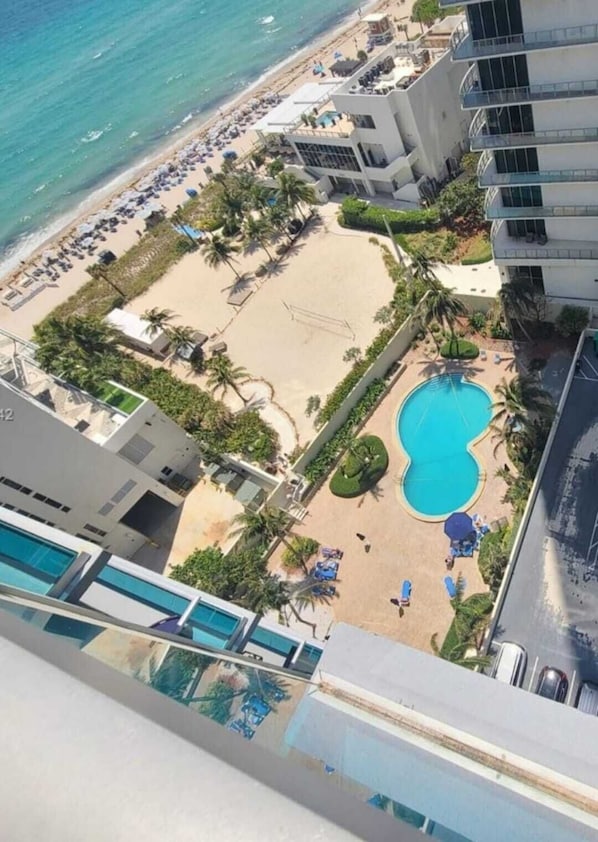A high-rise hotel with a pool, beach, and palm trees. - Cozy Ocean View Apartment by Miami Te Espera (Hallandale, Miami)