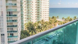 A high-rise hotel with multiple balconies, a view of the ocean, and a parking area below. - Cozy Ocean View Apartment by Miami Te Espera (Hallandale, Miami)