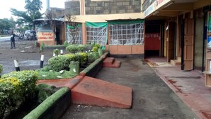A hotel with a paved walkway, a green awning, and a sign for 'Ready Choma & Fry'. - Club 5 Restaurant (Nakuru)