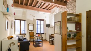 A living room with a sofa, chairs, a table, and a bookshelf. - Florence City Center Flat Via Dei Neri (Florence)