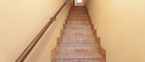 Una escalera con barandilla que lleva a un rellano.