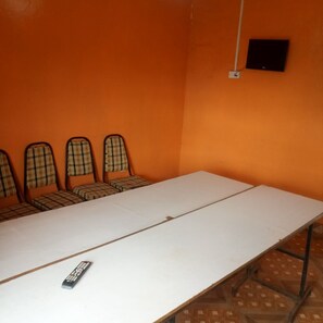 A conference room with a long table and four plaid-patterned chairs.
