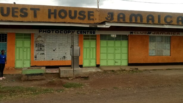 A building with a sign reading "WEST HOUSE JAMAICA" and a "PHOTOCOPY CENTRE" sign.