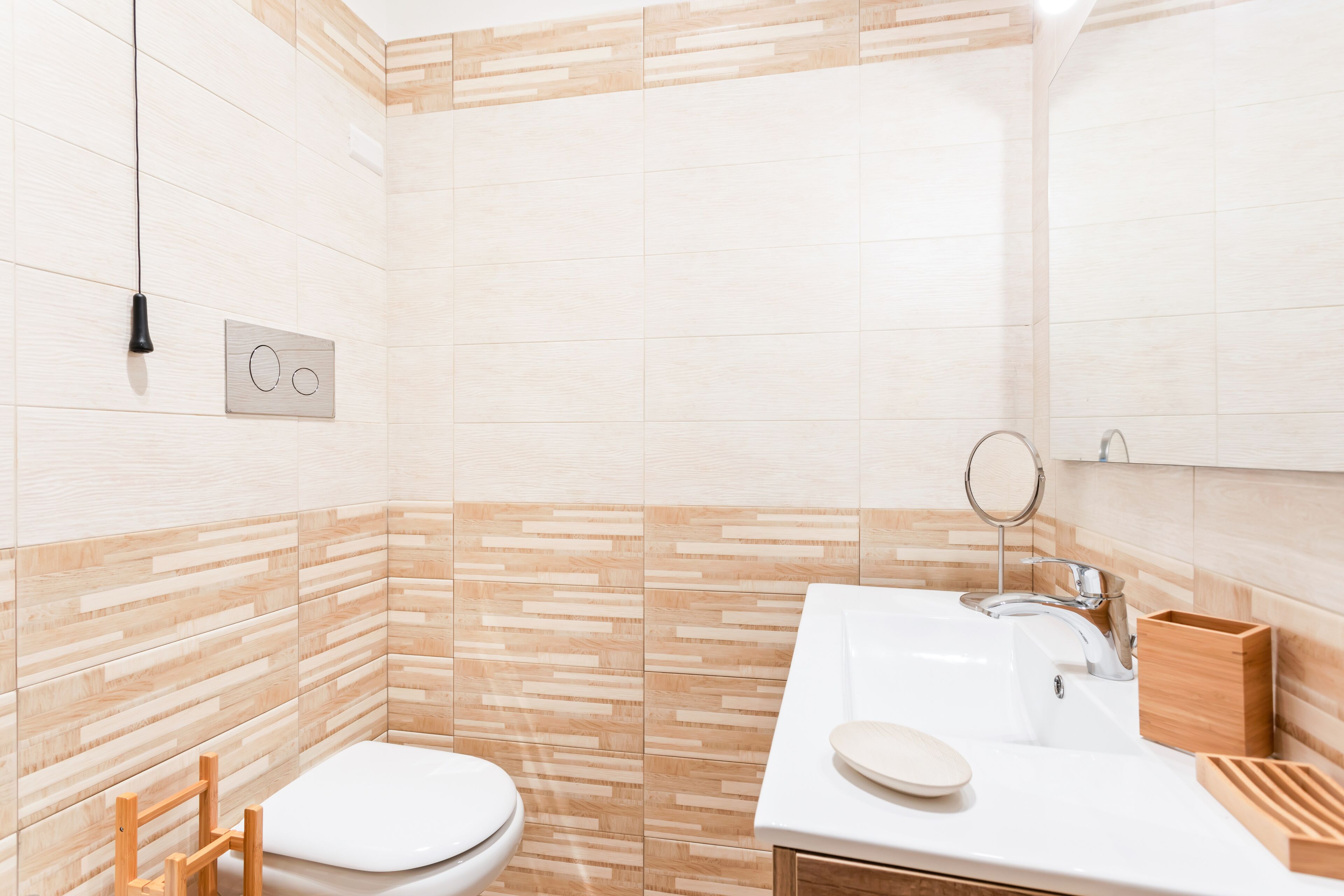 Ein modernes Badezimmer mit Toilette, Waschbecken und Spiegel.