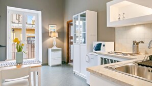 Eine moderne Küche mit integriertem Mikrowellenherd, Spüle und Essbereich mit Tisch und Stühlen.