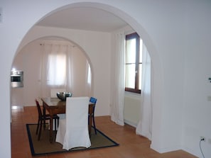 A dining area with a table, chairs, and a large window.