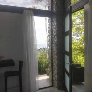 Una habitación con vistas a zonas verdes y un muro de piedra.