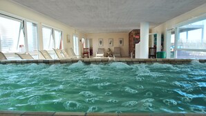 Un jacuzzi con chorros de agua, tumbonas y una estatua de Buda.
