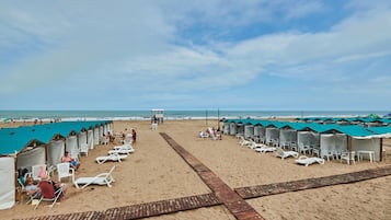 Privat strand, solstolar, parasoller och strandbarer