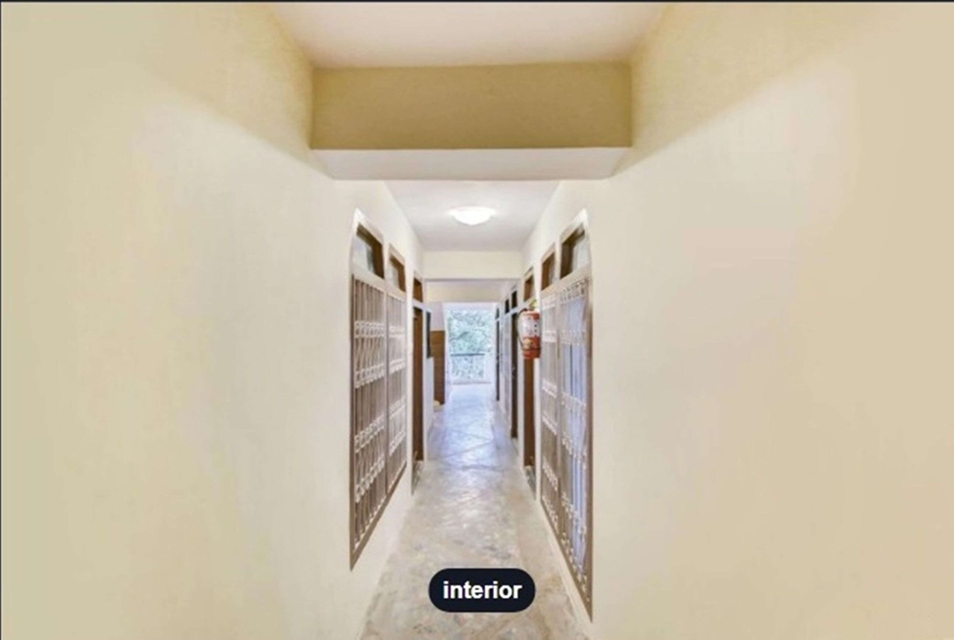 A corridor with tiled flooring and a ceiling light.