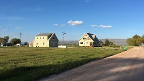 A rural road with two houses on either side, a clear sky, and distant mountains. - Bear Lake with View Guest House, Above Garage in Beautiful St. Charles (St Charles)