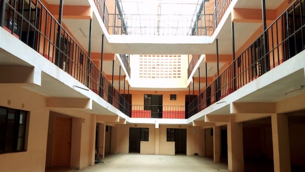A spacious atrium with a high ceiling and a central open area, surrounded by balconies with railings. - Rene Bistro Hotel (Nanyuki)