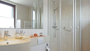 A modern bathroom with a sink, mirror, toilet, and glass-enclosed shower. - Harmony beim Holzschnitzer (Dreis-Brück)