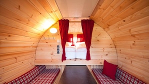 A cozy wooden cabin room with a bed, two benches, and a small table. - Harmony beim Holzschnitzer (Dreis-Brück)