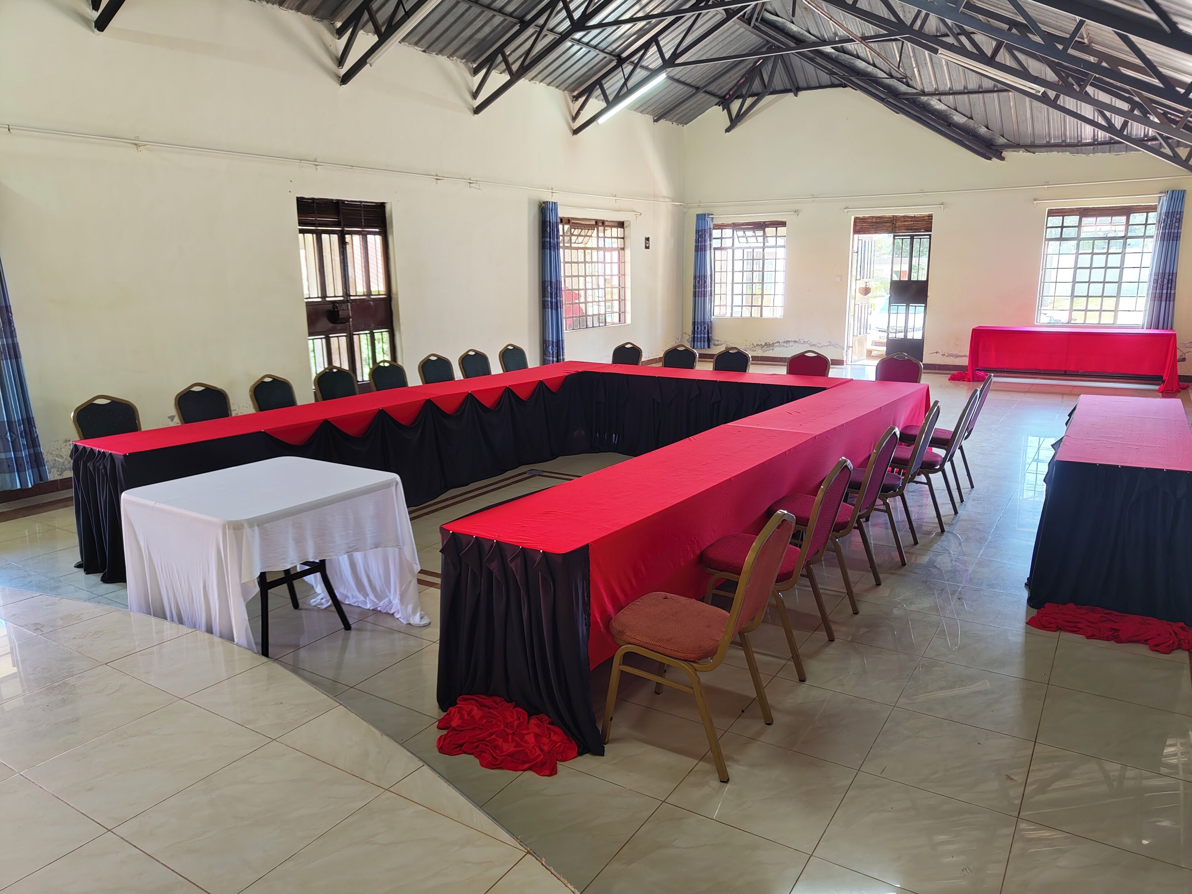 A conference room with a long table, chairs, and a high ceiling.