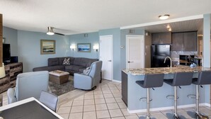 A modern apartment with a living room, a dining area, and a kitchen.