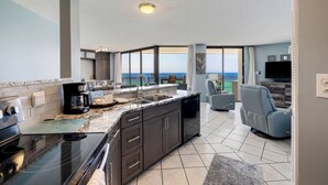 A modern kitchen with a large island, a dining area with a view, and a seating area with a view.