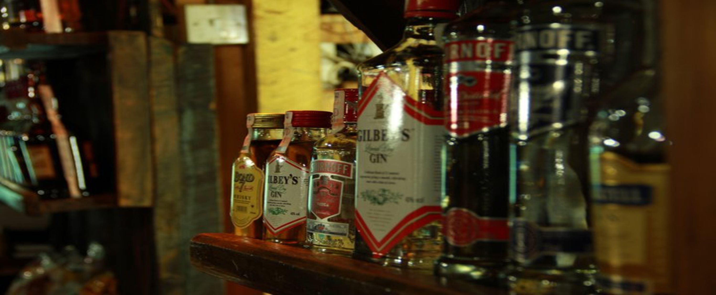 Bar com diversas garrafas de gin e outras bebidas espirituosas.