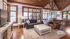 Ein geräumiges Wohnzimmer mit Holzböden, einem großen Sofa, einem Couchtisch und einem Essbereich mit Stühlen und einem Tisch.