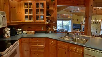 A wooden kitchen with cabinets, a sink, and a dishwasher.