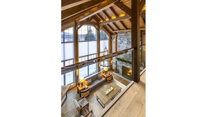 Ruime loft-achtige kamer met hoge plafonds, grote ramen en een gezellige zithoek met open haard.