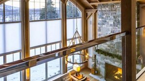 Une pièce spacieuse de style loft, avec de hauts plafonds, de grandes fenêtres et un coin salon confortable agrémenté d’une cheminée.