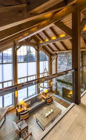 Une pièce spacieuse de style loft, avec de hauts plafonds, de grandes fenêtres et un coin salon confortable agrémenté d’une cheminée.