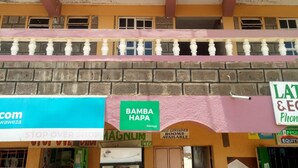 A building with a pink sign reading "2030 GUEST HOUSE" and a sign for "BAMBA HAPA" below. - 2030 Guest House (Nakuru)