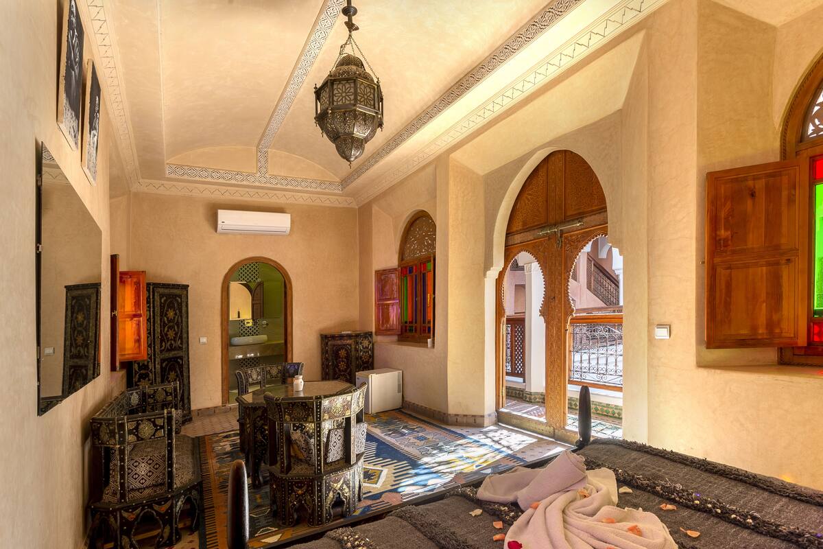 A traditional interior with ornate furniture, patterned rugs, and a hanging lantern.
