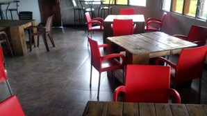 A restaurant interior with wooden tables and red chairs. - Albizia Club Nakuru (Sobea)
