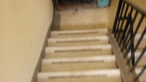 A staircase with wooden steps and a metal railing. - Amigos Guest House (Nakuru)