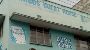 A building with a sign for 'Amigos Guest House' and 'Dura Bond' on the facade. - Amigos Guest House (Nakuru)