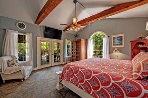 A bedroom with a large bed, a ceiling fan, a clock, and a fireplace. - Texoma/Tanglewood Highport Marina - Adorable Cottage!
(Pottsboro)